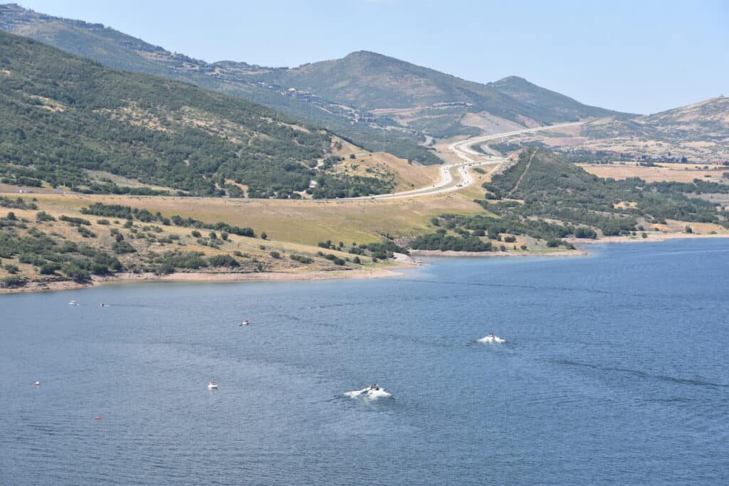 Boats power across the blue surface of Jordanelle Reservoir, a popular fishing spot in Utah.