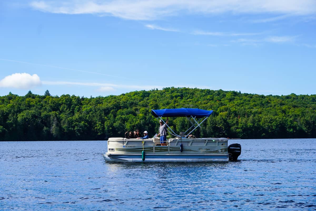 A pontoon fishing boat motors across Lake Placid.