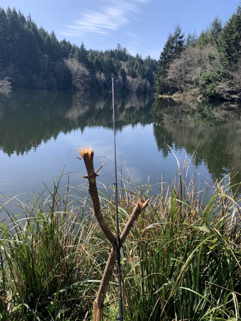 A fishing rod resting on a forked stick waits for a bite at Big Creek Reservoir 2 near Newport, Oregon.