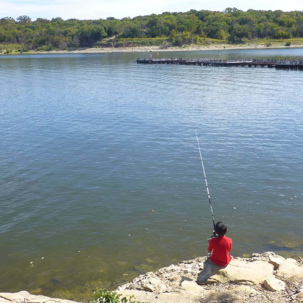 A boy fishes from the bank of Lake Texoma at Eisenhower State Park in Texas.