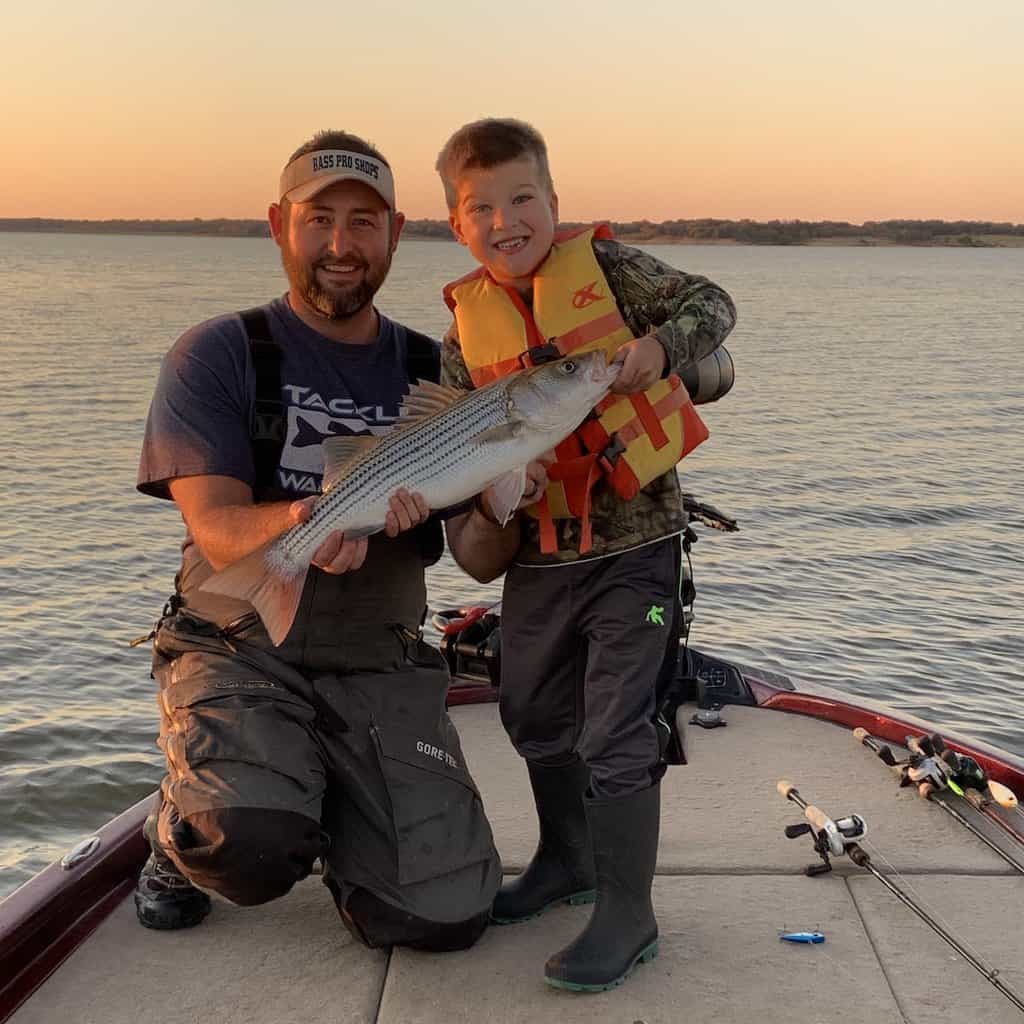 A fishing guide and a boy with a nice sized striped bass caught fishing at Lake Texoma on the Oklahoma - Texas border.