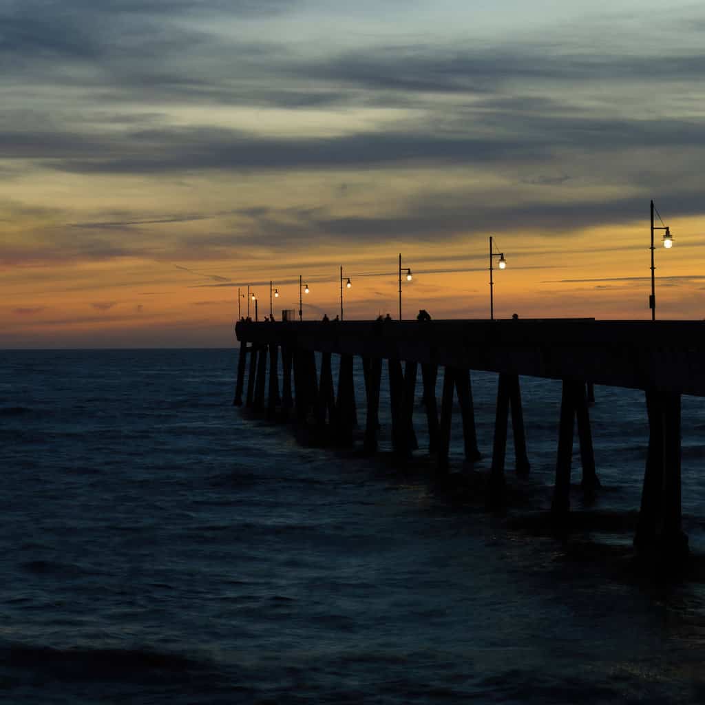 The sun setting behind Pacifica Pier, a popular fishing spot on the San Mateo County coastline.