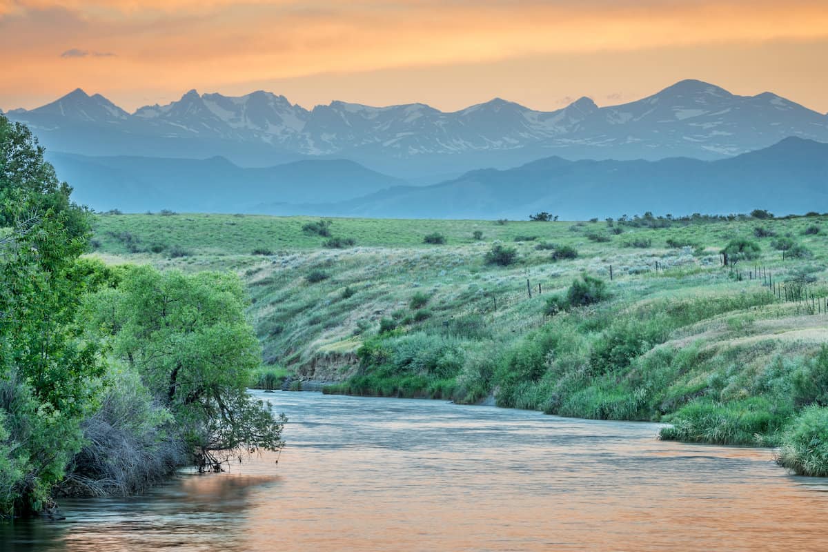 Scenic mountains rise in the background above St. Vrain Creek, one of the best fly fishing streams near Denver and Boulder.
