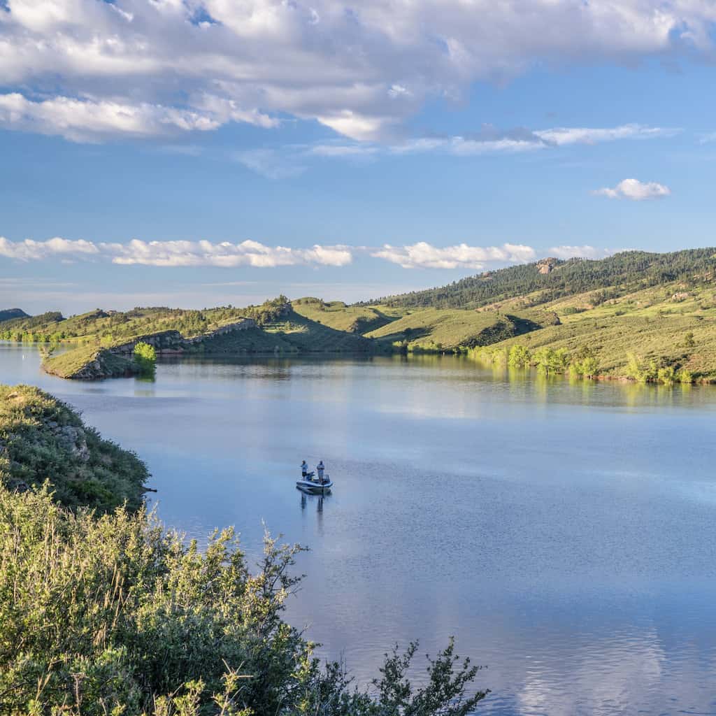 A fishing boat on the surface of Horsetooth Reservoir, a popular walleye fishing spot in Colorado.