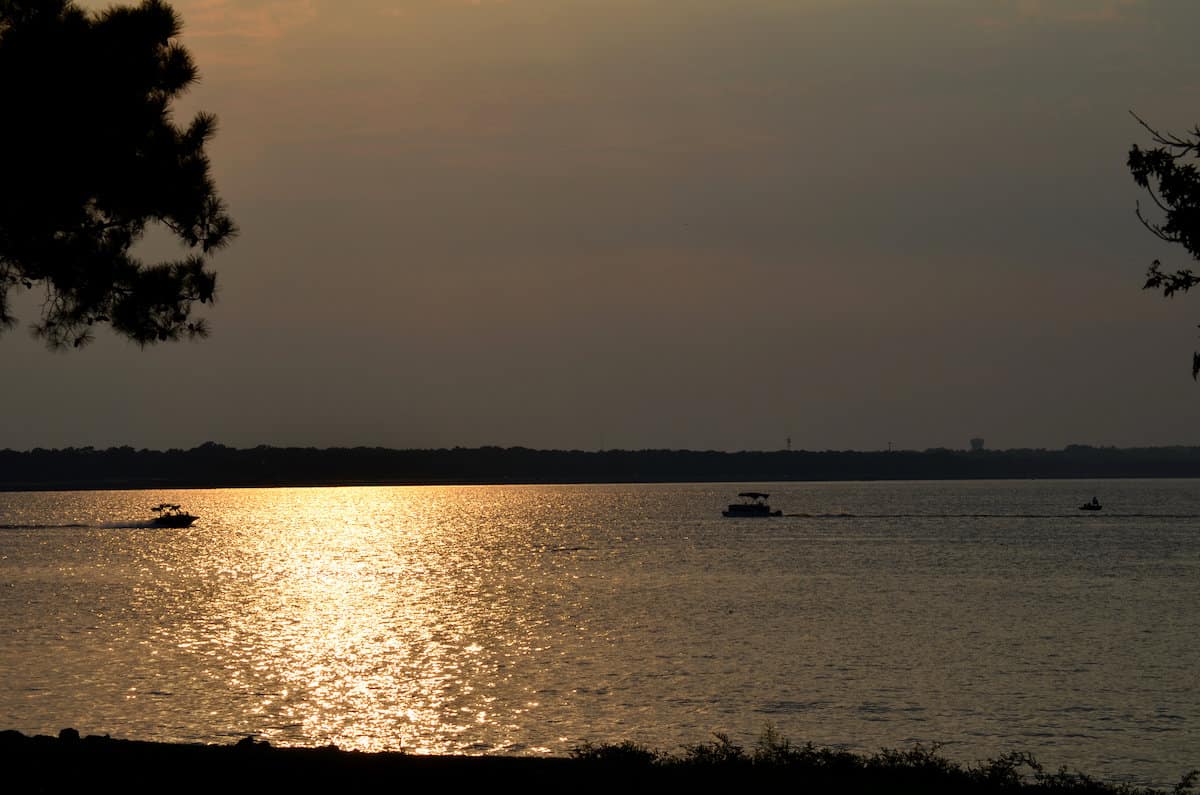 A couple of fishing boats on the surface of Ross Barnett Reservoir in Mississippi at sunset, a perfect time for crappie fishing.