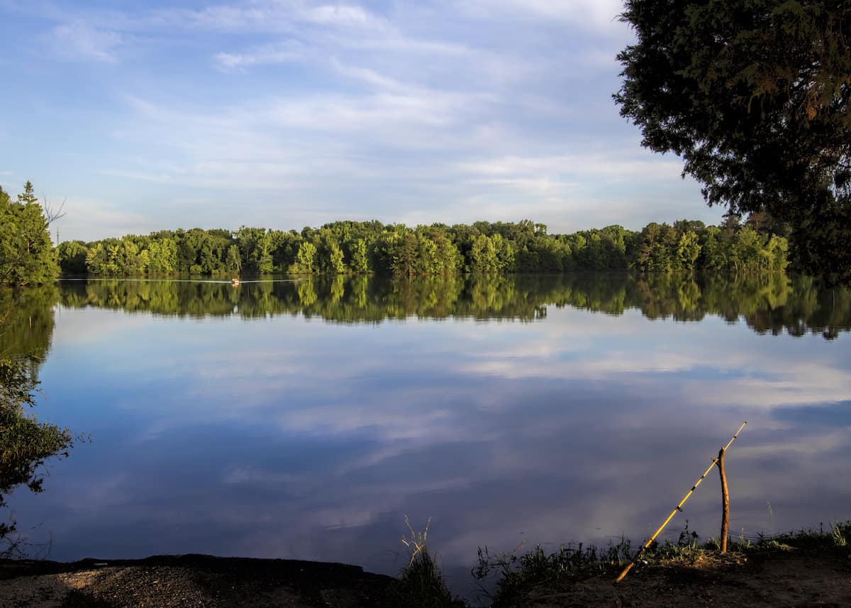 A fishing pole propped up on a wide river or reservoir in northeastern Alabama, home to excellent catfish fishing.