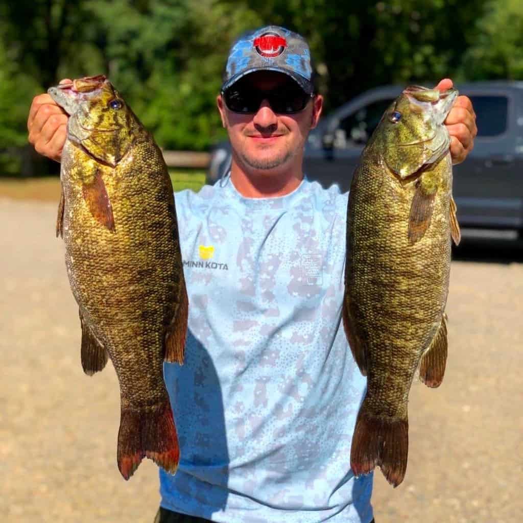 Professional angler Alex Wetherell holds two giant smallmouth bass he caught at Candlewood Lake in Connecticut.