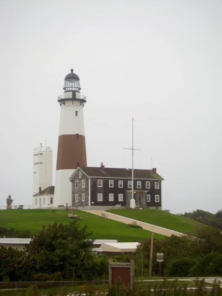 The iconic Montauk lighthouse standing at the end of Long Island, New York, above the rocks where anglers catch striped bass, bluefish and other sport fish.