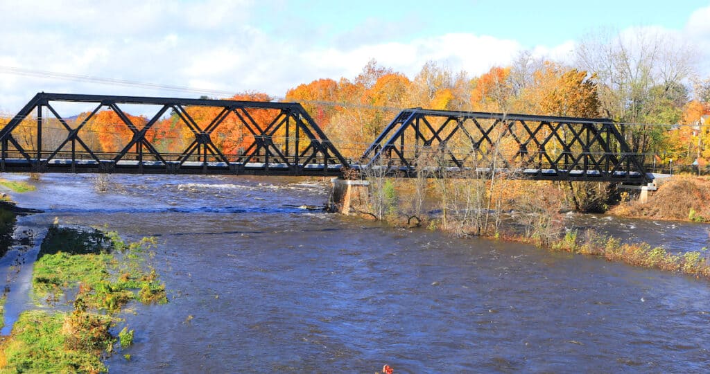 The Westfield River in Westfield, Massachusetts, with a railway bridge crossing the blue, riffled water.