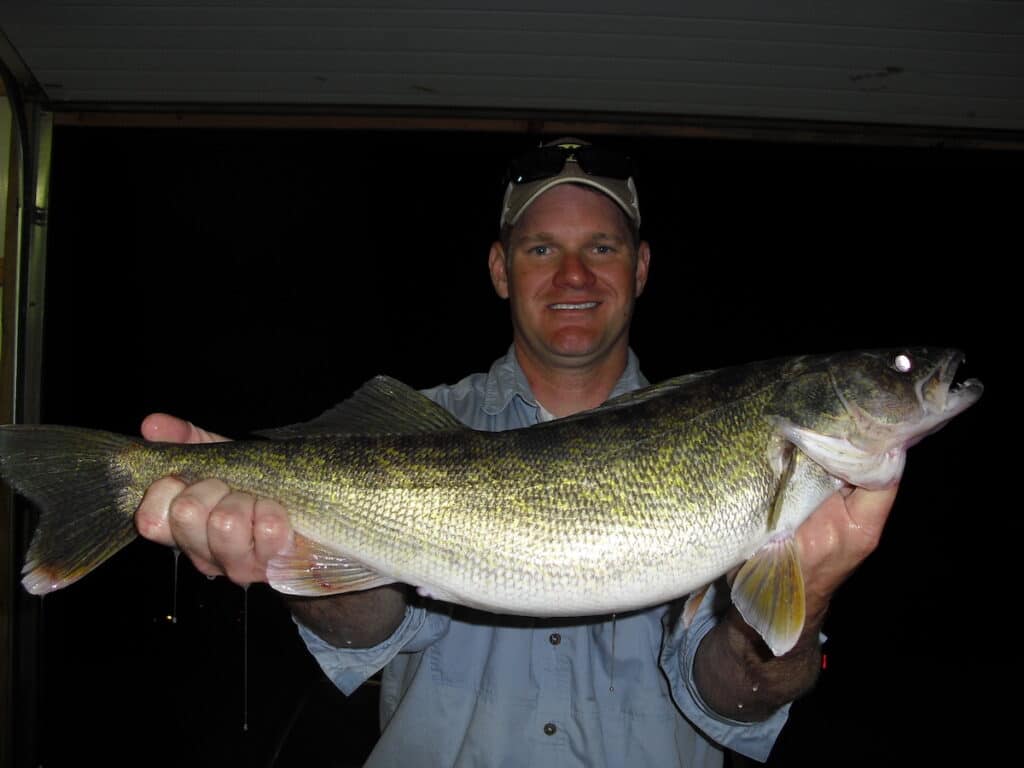 A man holds a very large walleye in the dark of night after catching it at Stockton Lake, Missouri.