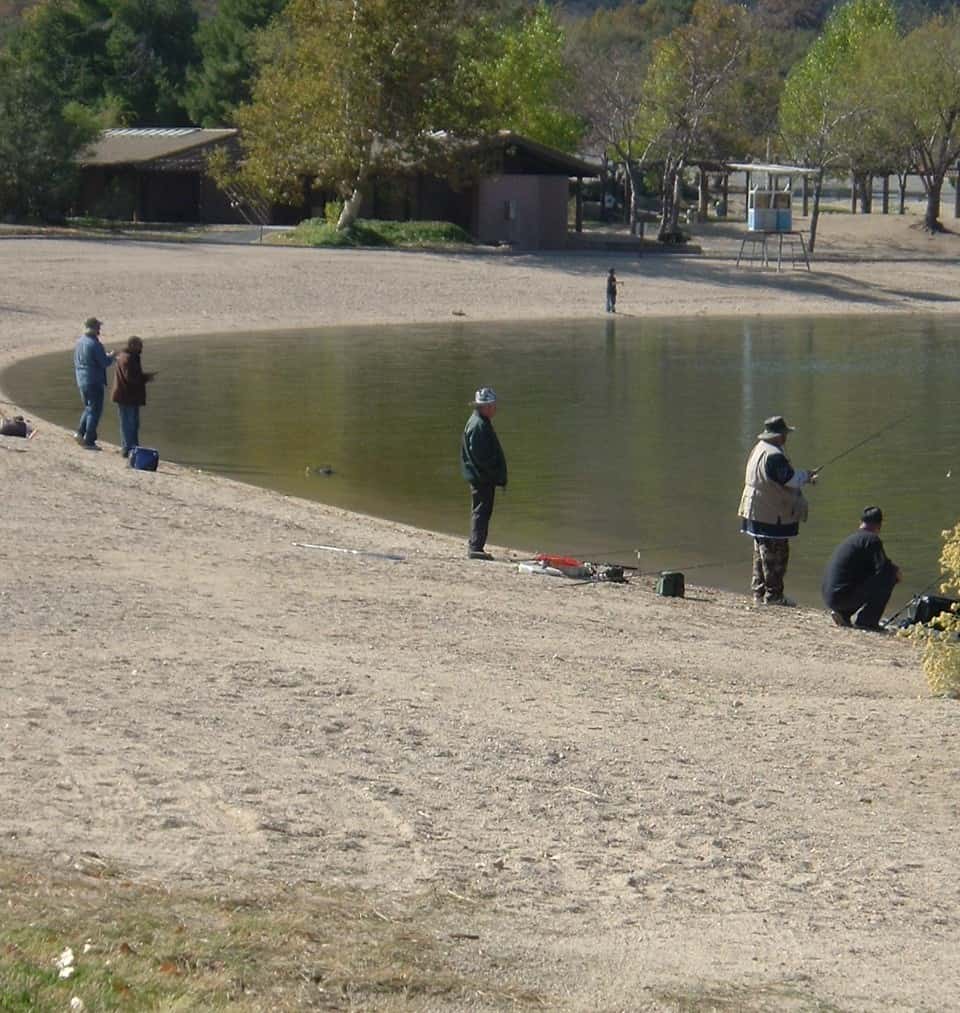 Anglers fish for trout along the bank at Silverwood Lake.