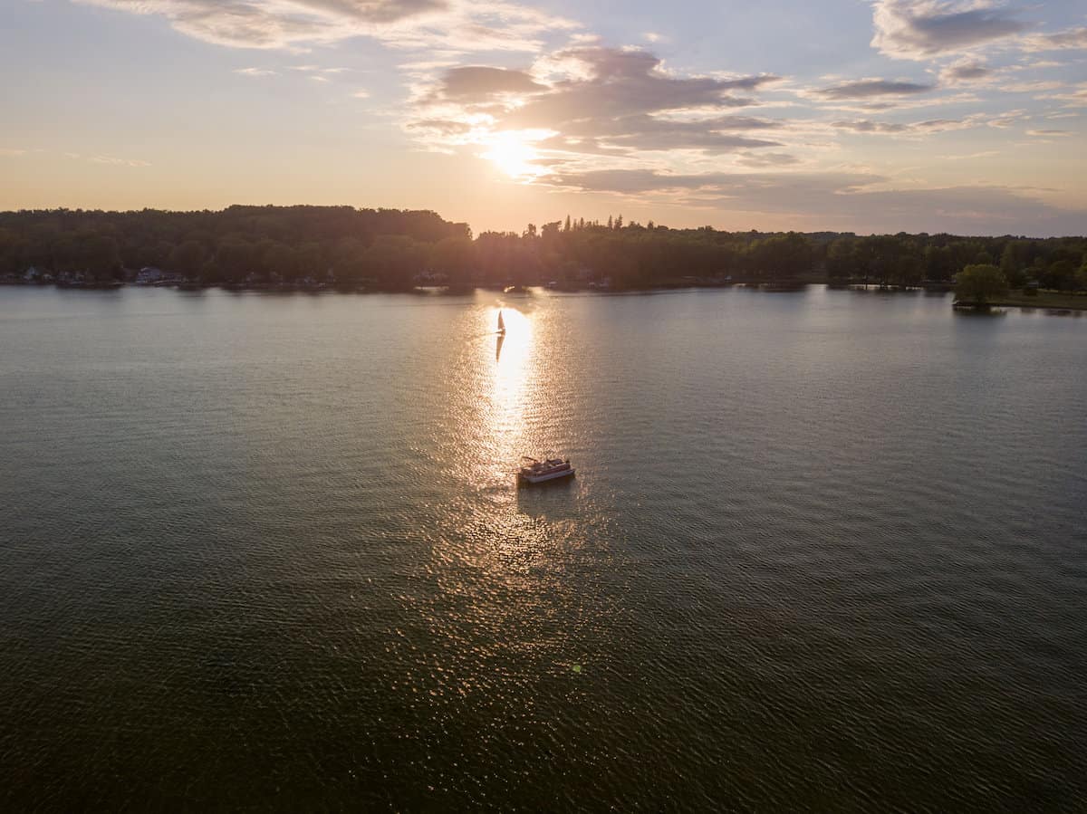 A fishing boat on Owasco Lake in the Finger Lakes region, with the sun setting on the distant horizon.