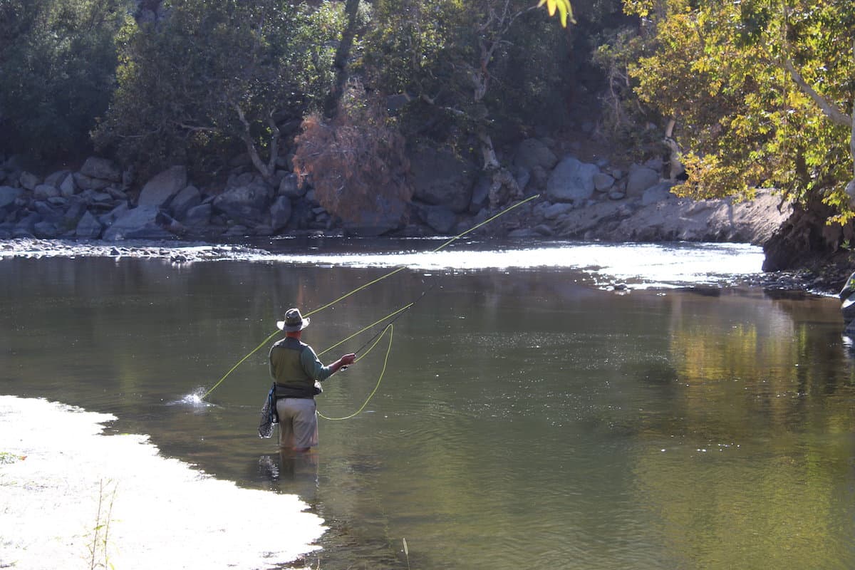 A fly fisherman battles a fish on the Lower Kern River.