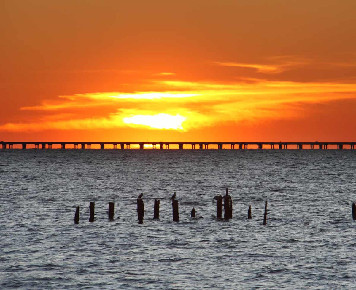 Sunset falls beyond the causeway crossing Lake Pontchartrain, marking both a great time of day and location for fishing the New Orleans lake.