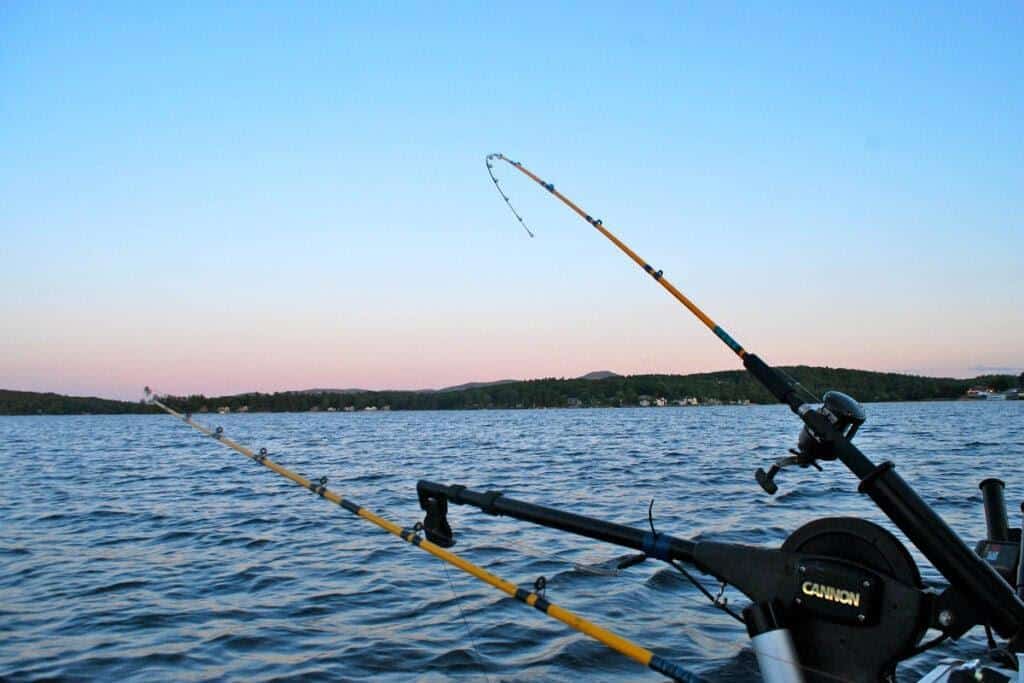 Fishing rods and a downrigger trolling on the surface of Lake Winnipesaukee.