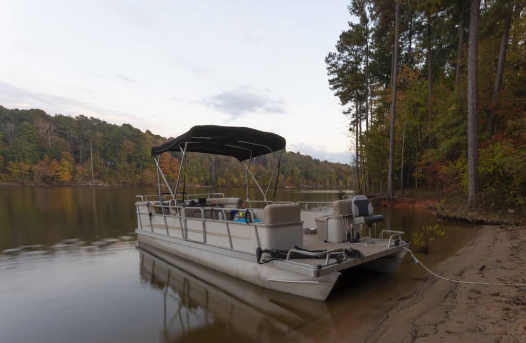 Pontoon fishing boat beached at Falls Lake in North Carolina during the early fall.