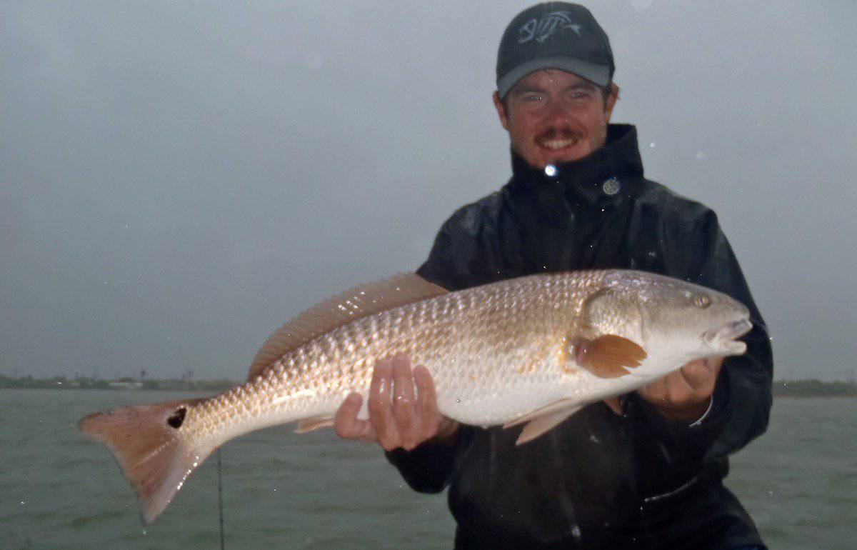 Author Rick Bach holding a very large redfish he caught fishing in Texas.