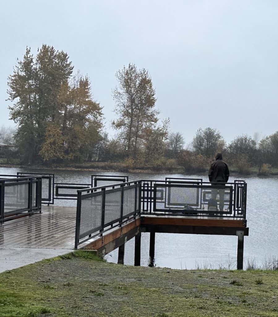 Angler watches for a bite while fishing for trout from the dock at Junction City Pond.