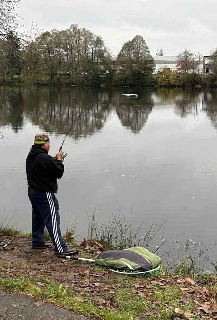 An angler fights a nice hatchery rainbow trout from the bank at Waverly Lake in Albany.