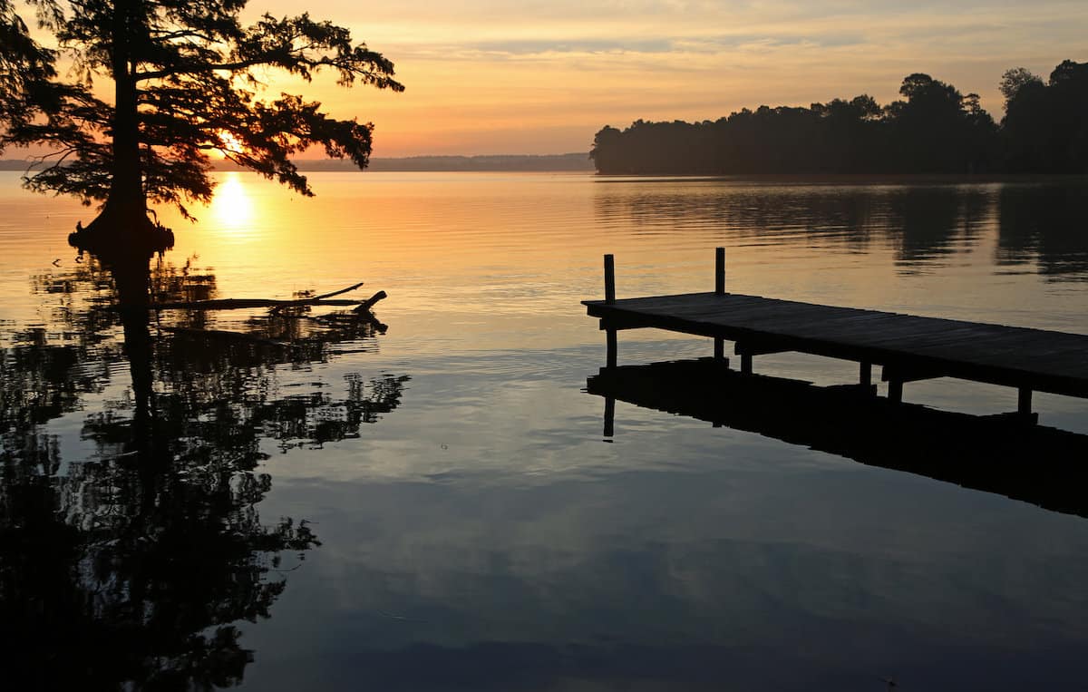 The sun begins to rise over Reelfoot Lake, a great time and place for catfishing in Tennessee.