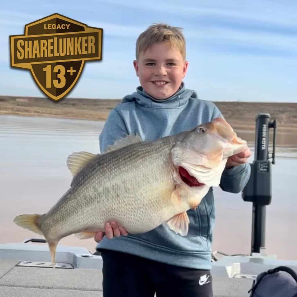 Stetson Davis, 11, holds the giant bass he caught at Lake J.B. Thomas.