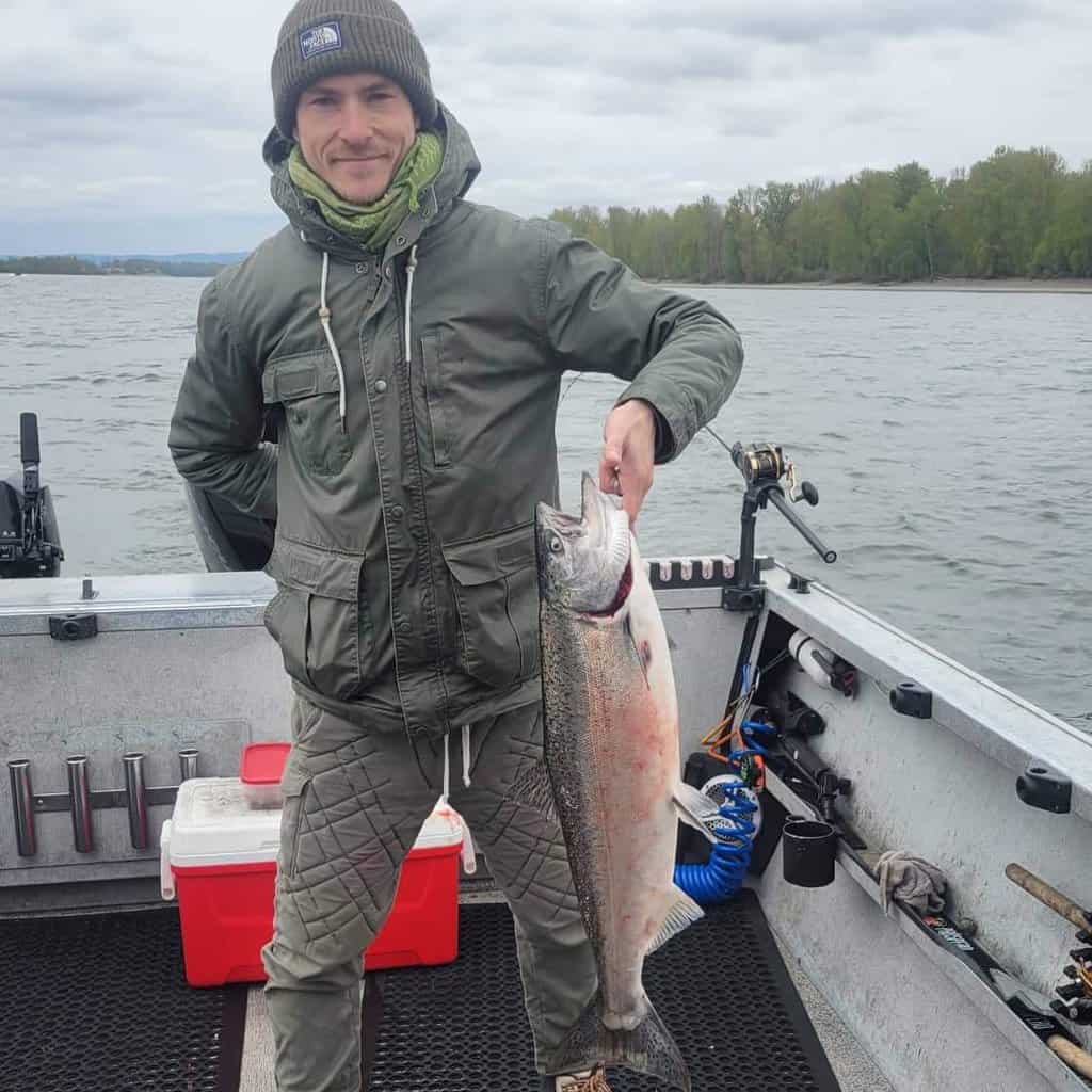 A happy fisherman holds up a spring chinook he caught on the Columbia River in early April 2024.